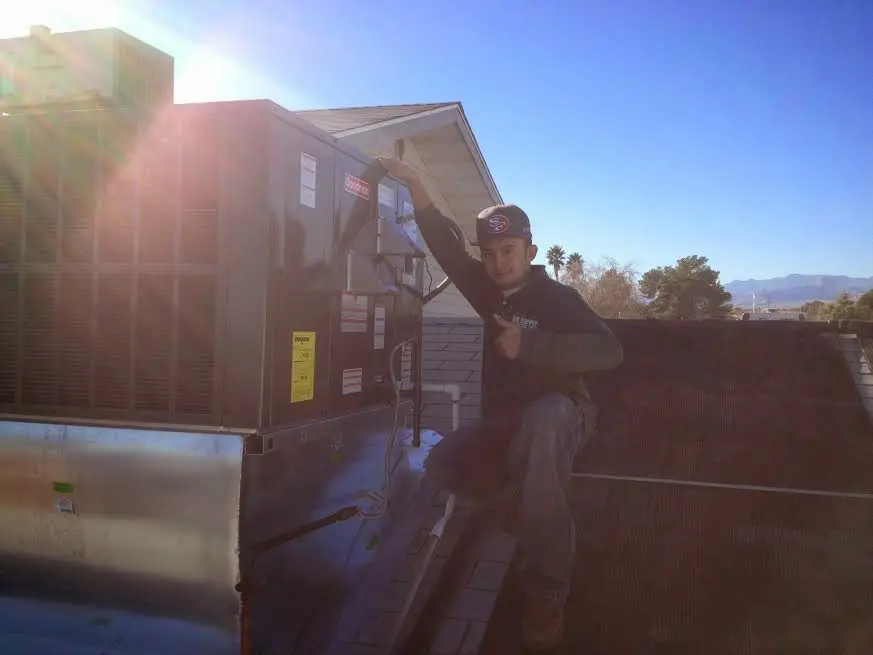 HVAC technician performing Air Duct Cleaning on a rooftop unit in Shoreline